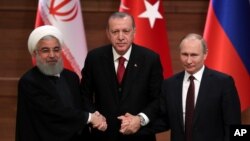  Iran's President Hassan Rouhani, left, Russia's President Vladimir Putin, right, and Turkey's President Recep Tayyip Erdogan lock hands during a group photo in Ankara, Turkey, Wednesday, April 4, 2018.