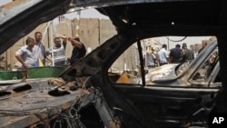 People gather at the scene of a bomb attack in Baghdad's Shiite enclave of Sadr City, Iraq, Monday, July 23, 2012.