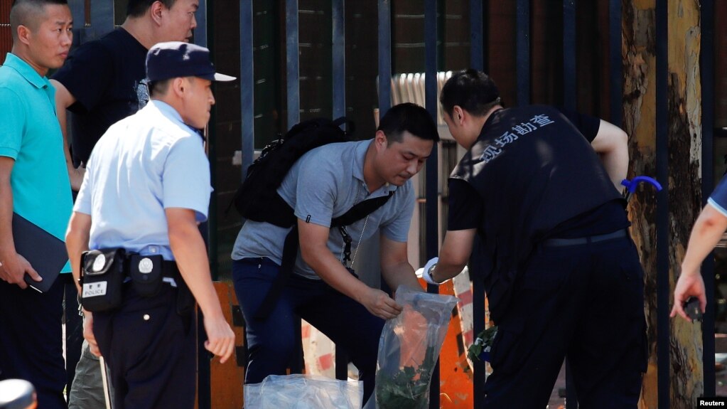 Personal de seguridad e investigadores trabajan afuera de la Embajada de EE.UU. en Beijing, luego de una explosión en el lugar. Julio 26, 2018.