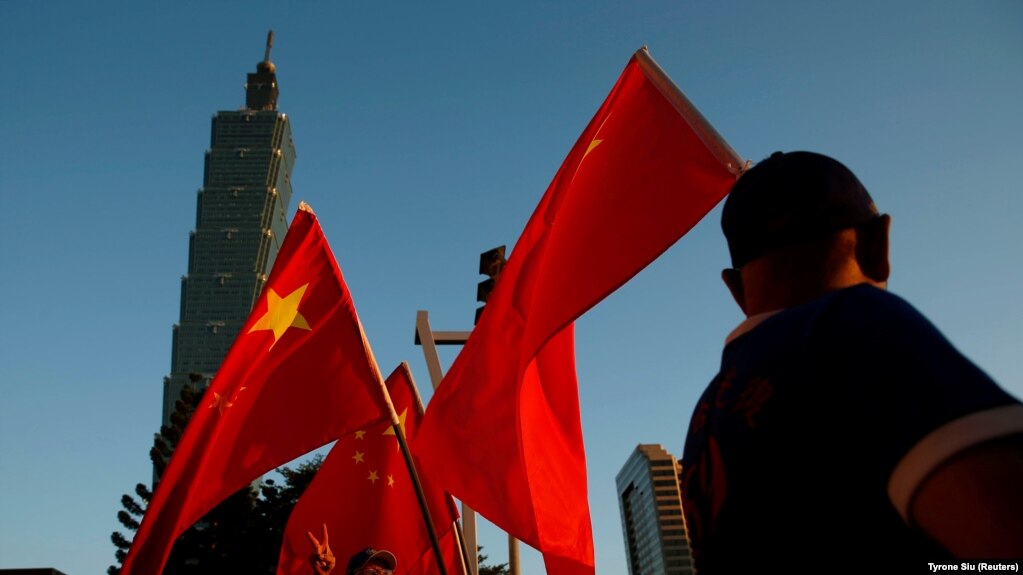 资料照：一些支持中国的台湾人在台北101大楼前举着中国国旗。(该照片拍摄时间为2016年8月22日，路透社提供)(photo:VOA)