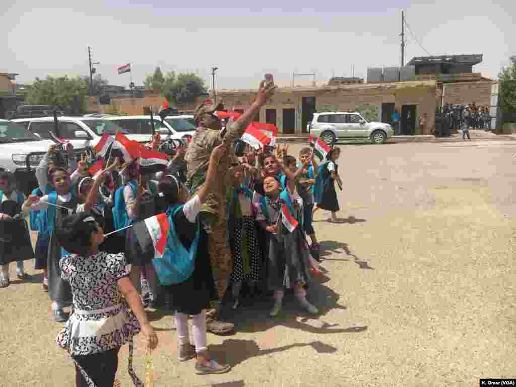 Seorang tentara Irak sedang berswafoto dengan para pelajar Sekolah Dasar Belqis (bagian kanan Mosul) 18 Juli 2017.