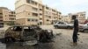 Seorang tentara yang setia kepada pemerintahan Libya yang diakui PBB (GNA) berdiri dekat sebuah mobil yang hancur setelah serangan di kawasan Bab Bin Ghashir, Ibu Kota Libya, Tripoli, 9 Mei 2020.