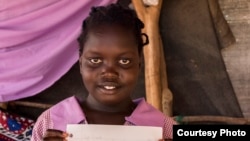 Stella Poni Vuni read a letter from Lucy, a student in Boulder, Colorado, and drew her a picture in return. She lives with her family who are refugees from South Sudan. (Carey Wagner/CARE)