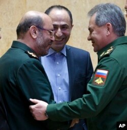 Mideast Iran Russia: FILE - In this Feb. 16, 2016 file photo, Russian Defense Minister Sergei Shoigu, right, and Iranian Defense Minister Gen. Hossein Dehghan shake hands during their meeting in Moscow, Russia.