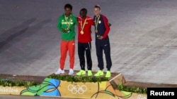 FILE - Gold medalist for the men's marathon Eliud Kipchoge of Kenya poses on the podium with silver medalist Feyisa Lilesa of Ethiopia and bronze medalist Galen Rupp of USA, Rio de Janeiro, Brazil, Aug. 21, 2016.