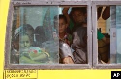 Indians living close to the border with Pakistan board a bus to move to safer places after authorities ordered the evacuation of villages near the highly militarized Line of Control dividing Kashmir, at Narana village in Pallanwal, about 65 Kilometers from Jammu, Oct. 1, 2016.