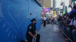 Un officier de police de New York met un genou à terre lors d'une manifestation à Times Square suite à la mort de George Floyd lors de son interpellation par un policier de Minneapolis le 31 mai 2020 à New York.