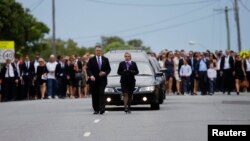The hearse carrying Australian cricketer Phillip Hughes is followed by thousands following his funeral in Hughes' home town of Macksville, Dec. 3, 2014. 