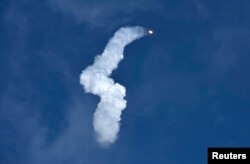 A SpaceX Falcon Heavy rocket leaves a smoke trail behind after lifting off from historic launch pad 39-A at the Kennedy Space Center in Cape Canaveral, Florida, Feb. 6, 2018.
