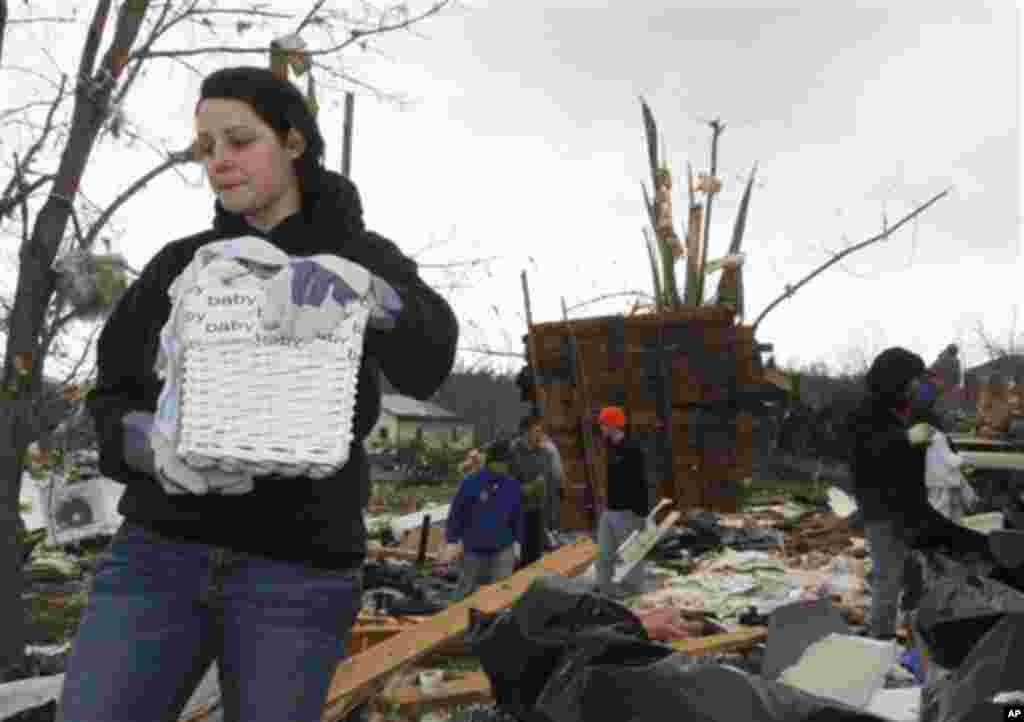 Stacey Loyd recovers her baby's personal items from her house after it was destroyed by a tornado on Friday that hit the village of Moscow, Ohio, Sunday, March 4, 2012.