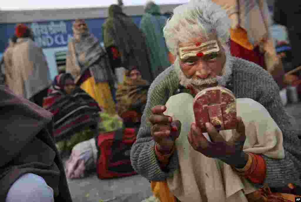 A Hindu holy man applies vermillion as he waits on platform 6 to leave the station in Allahabad, India, Feb. 11, 2013.