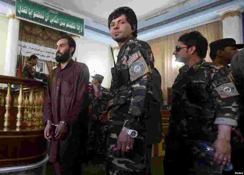 Afghan security personnel escort defendants at the Primary Court in Kabul, May 2, 2015. 