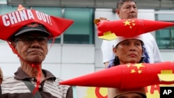 Protesters wearing boat-shaped paper hats and mock missiles, join others in a rally at the Chinese Consulate to protest China's alleged continued militarization of the disputed Spratly Islands in the South China Sea Feb. 10, 2018.