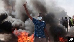 A man flashes the victory sign during a protest to denounce the October military coup, in Khartoum, Sudan, Dec. 25, 2021.