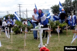 Manifestantes de pie junto a cruces en un monumento a las víctimas asesinadas en las recientes protestas contra el gobierno del presidente nicaragüense Daniel Ortega, durante una protesta en Managua, Nicaragua, el 4 de agosto de 2018. REUTERS / Oswaldo Rivas -
