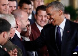 President Barack Obama talks with catcher David Ross, who retired after the World Series, during a ceremony in the East Room of the White House, Jan. 16, 2017. The Cubs have named Ross a special assistant.