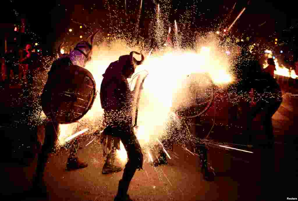 Revellers dressed as devils walk among fireworks during &quot;Correfocs&quot; (fire runs), traditional celebrations in eastern Spain with people dressed as dancing devils while lighting fireworks, to mark the end of the local festivities in Palma de Mallorca, Spain, Jan. 21, 2018.