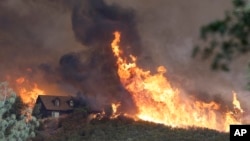 Fires approach a home near Lower Lake, Calif., July 31, 2015. A series of wildfires were intensified by dry vegetation, triple-digit temperatures and gusting winds.