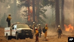 A fire crew stands watch along a fire break near a burn operation on the southern flank of the Rim Fire near Yosemite National Park in California, Aug. 30, 2013.