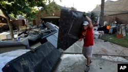 Tyler Moody removes a mattress from a friend's home after floodwaters recede from Tropical Storm Harvey, Aug. 31, 2017, in Houston, Texas.