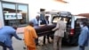 Des employés des pompes funèbres placent un cadavre dans un corbillard à Soweto, en Afrique du Sud, le 4 août 2020. 