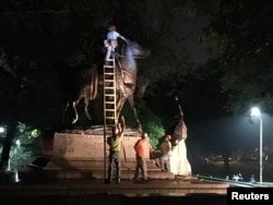 Workers remove the monuments to Robert E. Lee, commander of the pro-slavery Confederate army in the American Civil War, and Thomas "Stonewall" Jackson, a Confederate general, from Wyman Park in Baltimore, Maryland, Aug. 16, 2017.