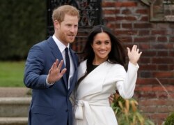 Britain's Prince Harry and his fiancee Meghan Markle pose for photographers during a photocall in the grounds of Kensington Palace in London, Monday Nov. 27, 2017.