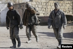 FILE - Miners are seen walking at one of the coal mines of the state-owned Longmay Group on the outskirts of Jixi, in Heilongjiang province, China, Oct. 24, 2015.