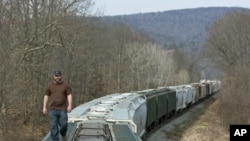 Chief Operating Officer of Wellsboro & Corning Railroad, Bill Myles, examines the end of a 75-car train carrying sand - used in hydraulic fracturing operations - that his company transloads for energy companies drilling natural gas wells in Wellsboro, Pen