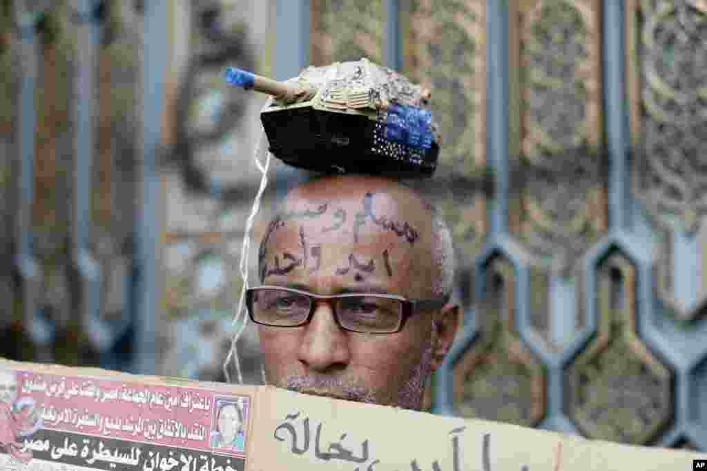 An Egyptian protester with Arabic writing on his forehead that reads, &quot;Muslims and Christians, one hand,&quot; attends a demonstration outside the presidential palace, in Cairo, Egypt, Dec. 5, 2012. 