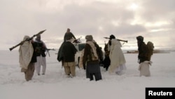 In this picture released exclusively to Reuters Jan. 17, 2009, Taliban militants are seen with their weapons in an undisclosed location in Afghanistan. With recents attacks, the group has been defying a longstanding practice of 'winter lull,' 'spring offensive.’