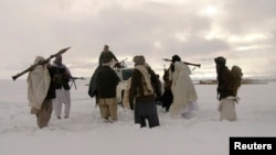 FILE - In this picture released exclusively to Reuters Jan. 17, 2009, Taliban militants are seen with their weapons in an undisclosed location in Afghanistan.