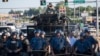 Riot police stand guard as demonstrators protest the shooting death of teenager Michael Brown in Ferguson, Missouri, Aug. 13, 2014. 