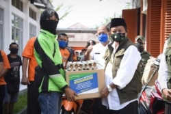 Wakil Gubernur Jawa Barat (Jabar) Uu Ruzhanul Ulum menyalurkan bantuan sosial (bansos) provinsi untuk warga Kota Banjar terdampak COVID-19 di Kantor Pos Kota Banjar, Rabu (29/4). (Courtesy: Humas Jabar)