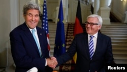 U.S. Secretary of State John Kerry (L) and German Foreign Minister Frank-Walter Steinmeier shake hands as they conclude remarks to the media in Vienna, Austria, July 13, 2014. 