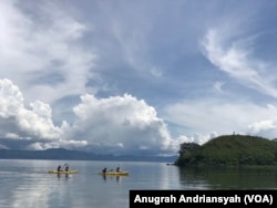 Dua orang warga tengah mengayuh sampan di Danau Toba, Sumatra Utara. (Foto: VOA/Anugerah Adriansyah) (Foto: Anugrah Andriansyah)