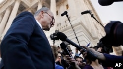 As a bitterly divided Congress moves toward a government shutdown, Senate Minority Leader Chuck Schumer, D-N.Y., center, speaks to the media outside the Capitol after meeting with President Donald Trump, Jan. 19, 2018, in Washington.