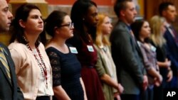 Legislative aides stand in unison during the reading of a Democratic resolution calling for the expulsion of Colorado state Sen. Randy Baumgardner, R-Hot Sulphur Springs, during a debate on the chamber's floor April 2, 2018.