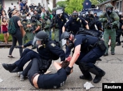FILE - A demonstrator is detained by police during protests in Baton Rouge, Louisiana, July 10, 2016.