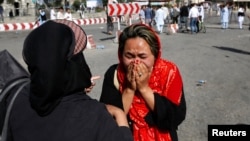 An Afghan woman weeps at the site of a suicide attack in Kabul, Afghanistan, July 23, 2016. 