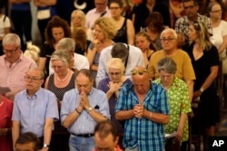 People pray at Sainte-Reparate Cathedral in Nice, France, during a mass in memory of the terrorist attack victims, July 15, 2016.