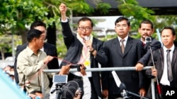 Sam Rainsy, leader of the opposition Cambodia National Rescue Party (CNRP), delivers a speech from a vehicle upon his arrival at Phnom Penh International Airport in Phnom Penh, July 19, 2014. 