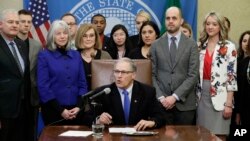 Washington Gov. Jay Inslee, center, speaks before signing a bill March 5, 2018, in Olympia, Wash., that makes Washington the first state to set up its own net-neutrality requirements in response to the Federal Communications Commission's recent repeal of Obama-era rules.