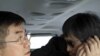 In this photo released by the US Embassy Beijing Press Office, blind lawyer Chen Guangcheng makes a phone call as he is accompanied by U.S. Ambassador to China Gary Locke in a car on the way to a hospital in Beijing, May 2, 2012. 