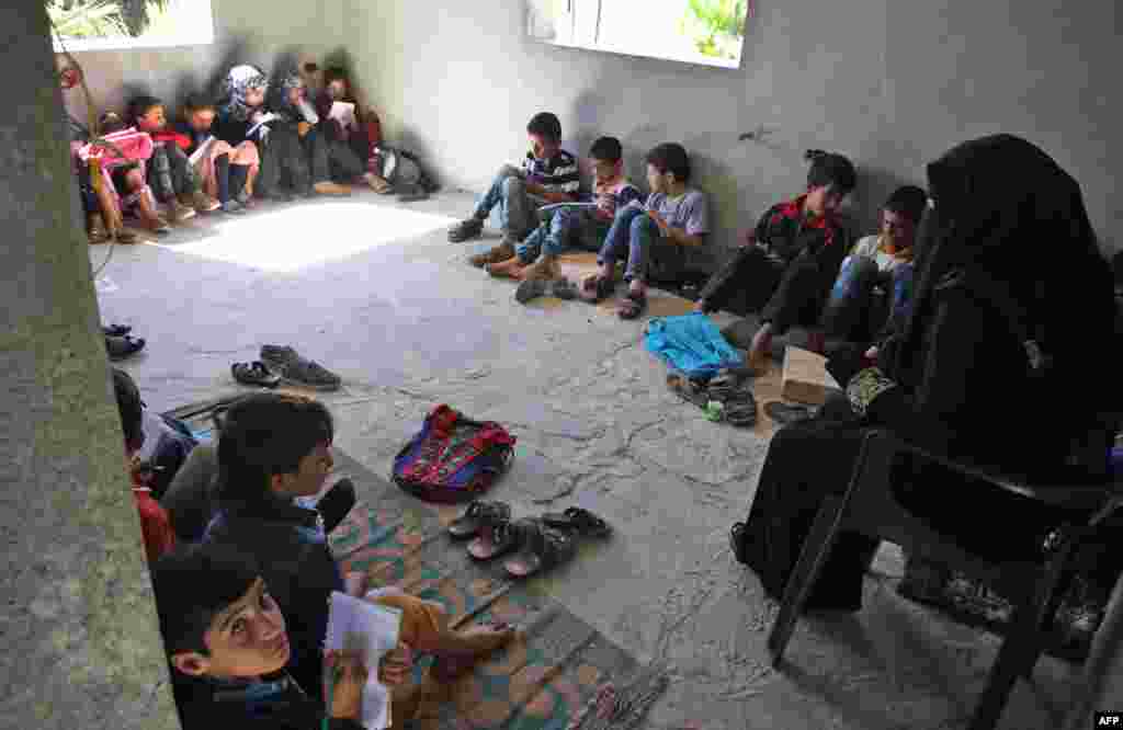 Displaced Syrian children attend class at a makeshift school in the village of Muhandiseen, in the southwestern countryside of the Aleppo province, Sept. 24, 2018.