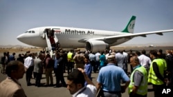 Yemeni airport, security and transportation officials greet a plane from the Iranian private airline, Mahan Air after it lands at the international airport in Sanaa, Yemen, Sunday, March 1, 2015. 