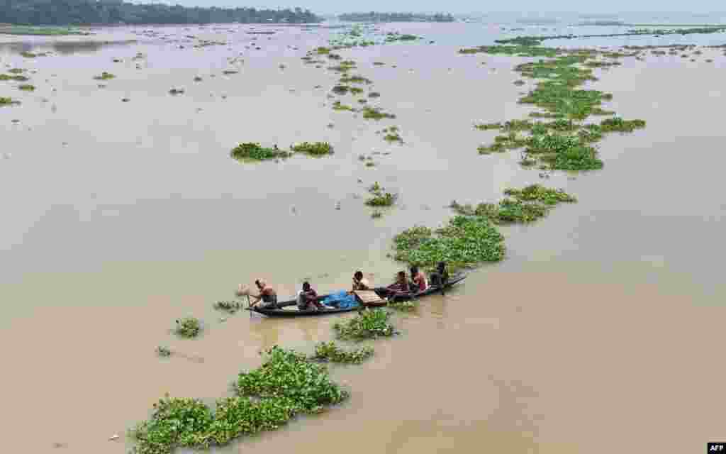 Indian villagers paddle a boat in flood-affected Ashigarh village in Morigoan district, in India's northeastern state of Assam.