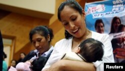 FILE - Women breastfeed their babies during a breastfeeding contest organized by Peru's Health Ministry in Lima, Peru, Aug. 26, 2016.