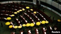 Các nhà lập pháp ủng hộ dân chủ cầm dù vàng, biểu tượng của phong trào Chiếm Trung tâm, bỏ về giữa cuộc họp của Hội đồng Lập pháp như là một hành động tẩy chay chính quyền ở Hong Kong, 7/1/2015. 