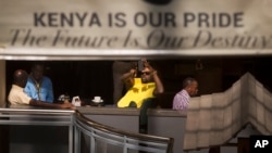 A man takes photographs of the mall with his smartphone while he sits in a cafe at the reopened Westgate Shopping Mall in Nairobi July 18, 2015. (AP Photo/Ben Curtis)